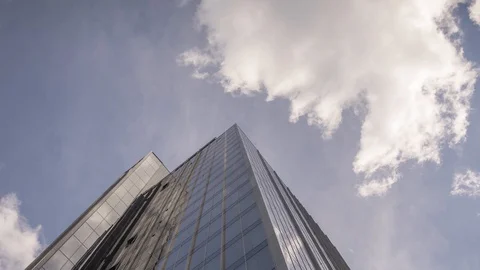 Zoom in time lapse skyscraper with clouds moving above in sky and Stock Footage 128189599