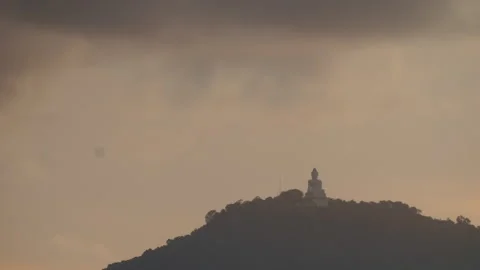 Zoom-in timelapse of the Big Buddha statue at sunset with foggy hills and Stock-Footage 317938010