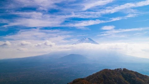 Zoom-in timelapse footage of moving clouds over Mount Fuji on a sunny day 動画素材 121939642