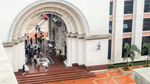Zoom in Timelapse of People rush through gate in Assumption University rainy Stock Footage 111164473