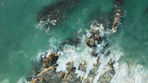 Zoom in top down aerial view waves splashing rocks Stock Footage 244401751