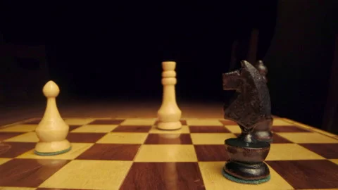 Zoom in toward white chess queen on chessboard Stock Footage 149016576
