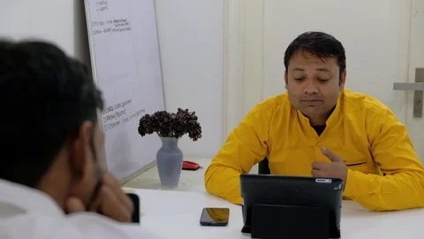 Zoom in to two office colleagues working on their computers and having animated Stock Footage 100025966