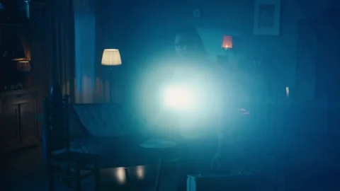 Zoom in video capturing two ghost hunters entering a dark room in search for Stock Footage 252381078