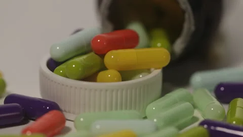 Zoom video out of different colored medicine capsules Stock Footage 250488963