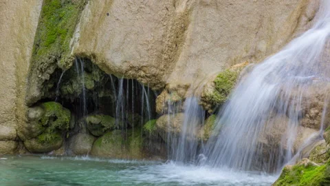 Zoom in view of a waterfall surrounded by moss-covered stones Stock Footage 151004276