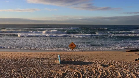 Zoom in to warning sign at Bondi beach of Sydney with waves and sand. Stock Footage 136729834