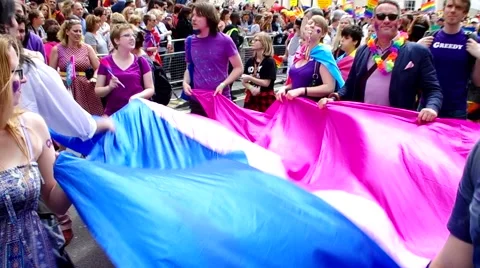 Zoom in to a waving flag whose colors are pink white blue ocean at the parade 库存影片 64926755