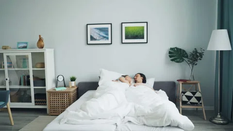 Zoom in of young people lying in bed kis... | Stock Video | Pond5