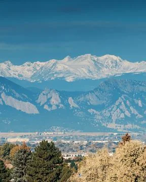 Zoomed in capture of multiple layers of mountains with snow and fall colors Stock Photos
