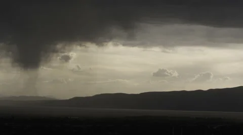 Zoomed in shot of rain clouds hovering over valley Stock Footage 52497213