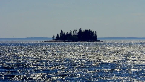 Zoomed in on a tiny island in the distance covered in trees surrounded by Video stock 117623086