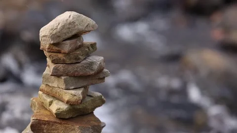 Zoomed In View Of Stacked Rocks With River Flowing Behind Stock-Footage 315225371