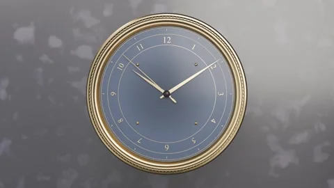 Zooming camera revealing wall-mounted round clock on room wall, revealing hands Stock Footage 337505103