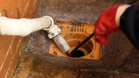 Zooming into drain blockage cleaning work Stock Footage 83955498