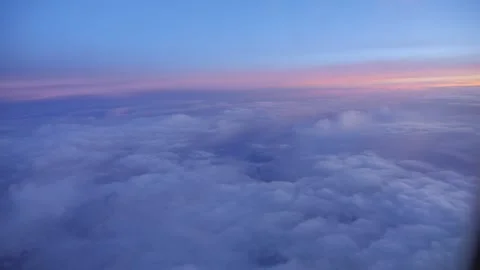 Zooming in or out on a cloud-filled sky through an airplane's window in 4k .. Stock Footage 264769600