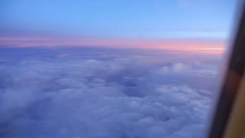 Zooming in or out on a cloud-filled sky through an airplane's window in 4k .. Stock Footage 264769604
