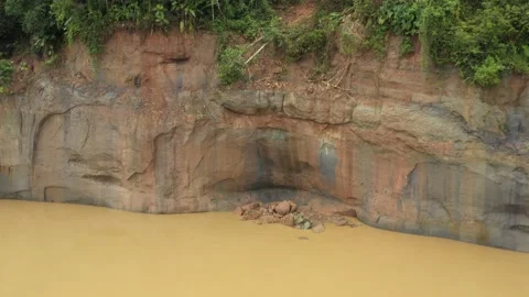 Zooming out on fallen rocks in a river showing a large cliff Stock Footage 142759638