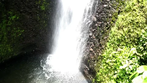 Zooming out on a large waterfall with a rainbow in front of it Stock Footage 151280955