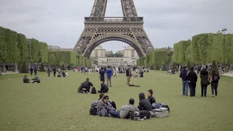 Zooming out on lawn in front of Eiffel Tower - man selling beer and wine - Paris Video stock 94006553