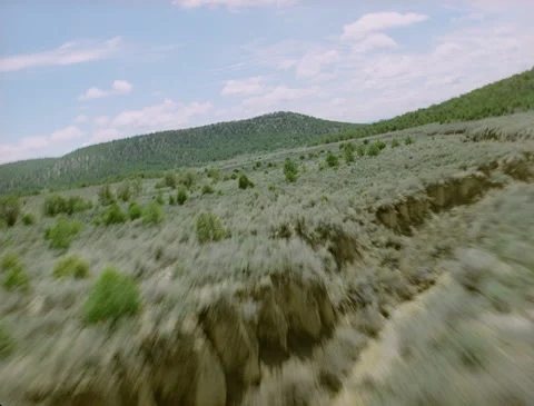 Zooming over gully and through rural valley 1989 Stock Footage 136072189