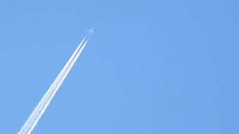 Zooming In On A Plane Spraying Chemtrails Contrails In The Sky Stock Footage 164781908