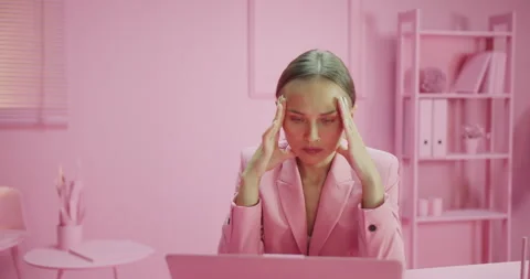 Zooming shot of serious female using laptop working stressed at totally pink Stock Footage 162415447