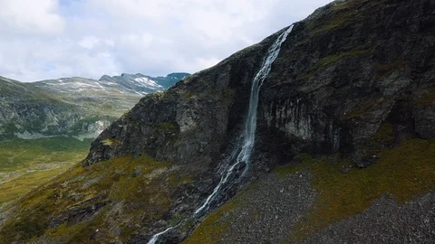 Zooming in to a stunning dramatic waterfall on a steep vertical cliff face Stock Footage 99681104