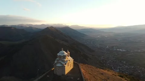 Zooming towards a small cathedral with view of the mountains in the background Video stock 241507666