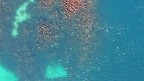 Zooming in of a turquoise water surface. Drone footage, drone going slowly down. Stock Footage 249483033