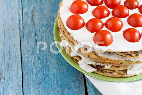 Zucchini cake with tomato and parsley on a blue wooden Stock Photos