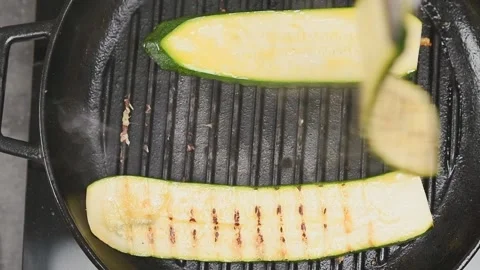 Zucchini on a grill pan. Chef prepares sliced zucchini. Stock Footage 153485604