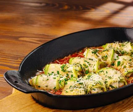 Zucchini involtini rolls baking in tomato sauce Stock Photos