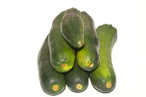 Zucchini lie on a white surface Stock Photos