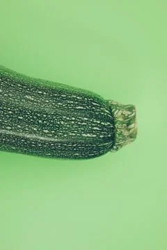 Zucchini on vibrant green background. Stock Photos