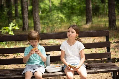 Zwei Kinder, ein Mädchen und ein Junge, essen selbstgebackenen Kuchen im P.. Stock Photos